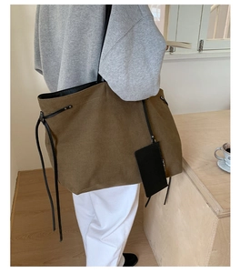 Detail shot of canvas tote bag with black drawstring side and detachable small pouch