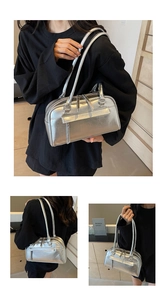 Detail of silver metallic Boston bag featuring glossy finish and stylish front zipper pocket
