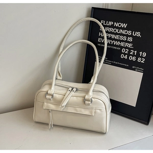Detail of cream white Boston bag featuring long shoulder straps and silver metal zippers