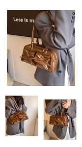 Close-up of brown patent leather shoulder bag featuring decorative double bows and silver zippers