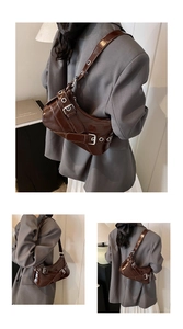 Macro view of dark brown glossy leather underarm bag featuring silver buckle hardware