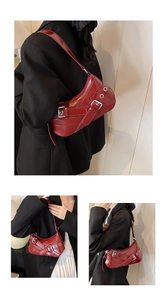 Detail view of burgundy patent leather baguette bag with metal buckles and eyelets strap
