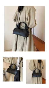 Close-up of black pebble grain leather purse with wide handle and cloud-like silhouette