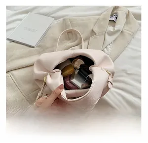 Detailed interior of pink dumpling bag showing spacious capacity and leather texture