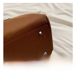 Detailed macro view of dark brown nylon tote base with protective silver metal studs