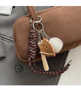 Nahaufnahme des Baseball-Taschenanhängers mit Handschuh und Schläger auf braunem Wildleder