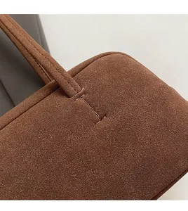 Details der sorgfältigen Handnaht und Kantenpressung an brauner Wildledertasche