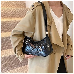 Détail du sac à bandoulière noir brillant style Y2K avec boucles et œillets métalliques