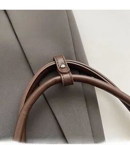 Gros plan d'une poignée en cuir marron foncé avec structure ronde et clou en métal argenté