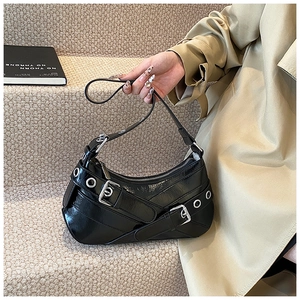Détail du sac sous le bras en cuir verni noir brillant avec boucles et quincaillerie punk