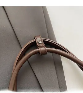 Détail de la bandoulière en cuir PU marron avec rivet en métal argenté et coutures fines