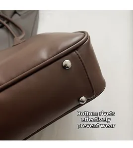 Détail du fond du sac en cuir PU marron avec rivets métalliques de protection argentés