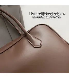 Détail des coutures faites main sur les bords d'un sac chic en cuir PU marron foncé