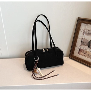 Details der schwarzen Baguette-Tasche mit matter Textur, Doppel-Reißverschluss und Anhänger