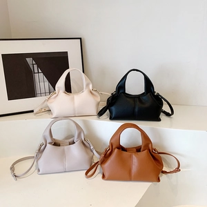 Minimalist ruched cloud dumpling bags in four colors on a white minimalist platform