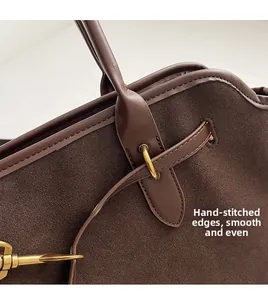 Close-up of suede tote bag with handcrafted stitched edges and smooth leather trim