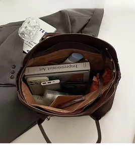 Spacious interior of a dark brown suede tote bag showing compartments and large capacity