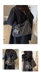 Detail of gray washed denim hobo bag featuring silver chain strap and mini pouch