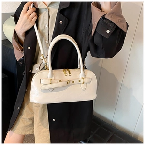 Detailaufnahme der cremefarbenen Schultertasche mit glattem Leder und metallischen Akzenten.