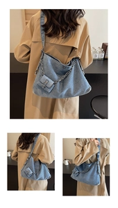 Detail of blue wash denim tote bag with metal chain strap and mini detachable pouch