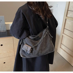 Detail of grey washed denim hobo bag featuring a metallic chain and mini coin pouch