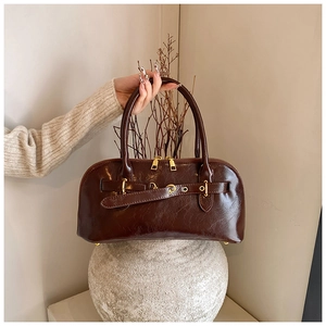 Nahaufnahme einer stylischen braunen Lederhandtasche im Vintage-Stil mit Goldbeschlägen