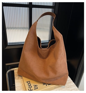 Close-up of the vintage brown suede texture and wide shoulder strap on the hobo tote bag