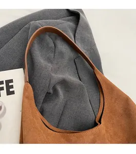 Dettaglio della trama della borsa hobo in pelle scamosciata marrone su un blazer