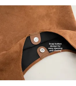 Dettaglio della chiusura magnetica argento sulla borsa a secchiello in camoscio marrone