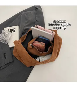 Dettaglio della borsa tote in pelle scamosciata marrone con capienza per tablet ed essenziali