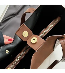 Detail of vintage brown tote bag with magnetic snap closure and golden hardware