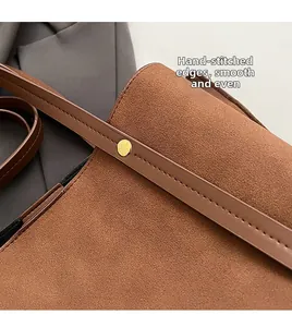 Detail of handcrafted stitching and gold stud hardware on brown vintage tote bag