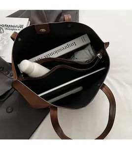 Top view of spacious brown leather tote interior with tablet and daily essentials