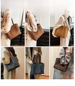 Detail view of large capacity tote bag in brown and khaki with decorative metal buckles