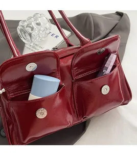 Détail du sac Boston bordeaux brillant avec double poche frontale magnétique et perles