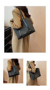 Close-up of matte black tote bag with gold lettering and metallic rivet detailing