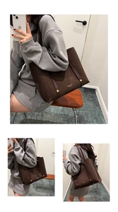 Detailed close-up of dark brown suede tote bag with gold logo and leather strap