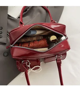Top view of red glossy tote bag interior showing spacious storage with personal items
