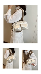 Detail of silver bow shoulder bag with pearl pendant and functional front pockets