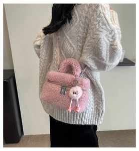 Détail d'un sac seau en peluche rose avec texture douce et breloque œil mignonne