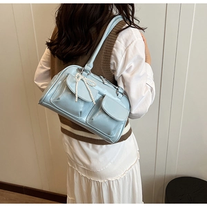 Détail d'un sac à bandoulière bleu clair brillant avec breloque nœud en perles
