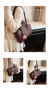Detail of a large dark brown leather bowling bag with twin straps and tassel charm