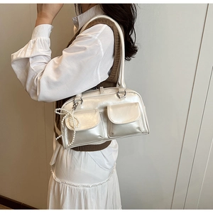 Vue détaillée du sac à bandoulière blanc nacré avec breloque nœud en perles sur le côté