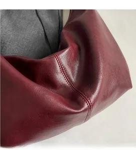 Detail of wine red leather tote showing soft texture and fine stitching craftsmanship