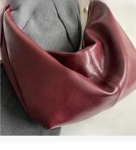 Detailed macro view of dark red Hobo bag showcasing soft PU leather grain and fine stitching