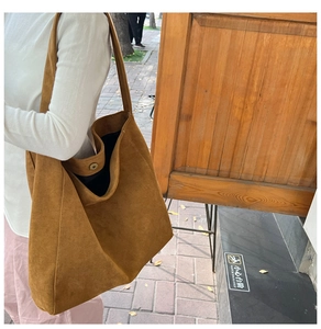 Detail of camel wool tote bag featuring wide shoulder strap and magnetic closure detail
