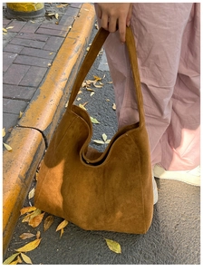 Detailed close-up of brown suede hobo tote bag with soft leather texture for autumn
