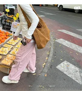 Brown suede tote bag side view shown on model in an outdoor casual street setting