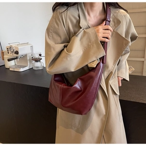 Chic burgundy crescent PU leather shoulder bag styled with an elegant beige trench coat