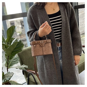 Detail of vintage brown crossbody bag with decorative belt buckle and metal rivets